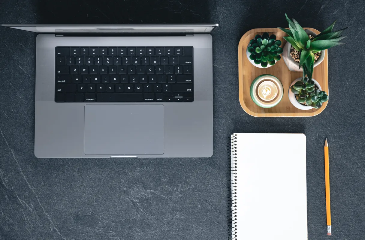 Developer workspace with MacBook, notebook, and coffee